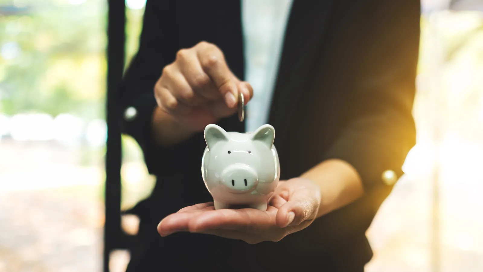 Financial Investing - a man putting a coin in the piggy bank